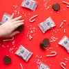 Theo Chocolate Peppermint Cocoa Cups, individually wrapped and open product on red background